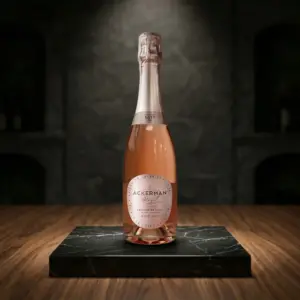 Botella de Crémant de Loire Rosé Brut 2024 Vintage de Ackerman sobre una peana de mármol negro